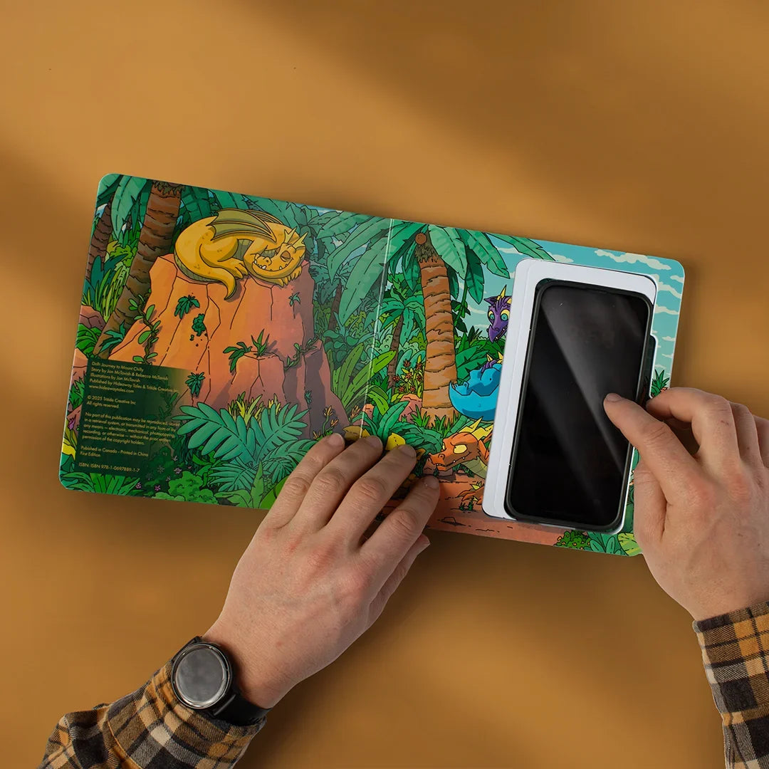 A parent holding the open Hideaway Book with a phone tucked inside its hidden foam-lined compartment.